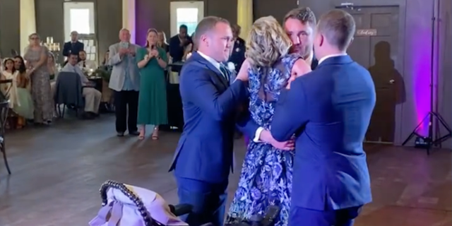 Kathy Poirier danced with her newly married son, Zak, on April 9, 2022. They received help from Zak's brothers, Nick and Jake, who helped their mother get to her feet. She is battling ALS.