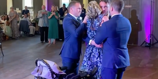 Kathy Poirier danced with her newly married son, Zak, on April 9, 2022. They received help from Zak's brothers, Nick and Jake, who helped their mother get to her feet. She is battling ALS.