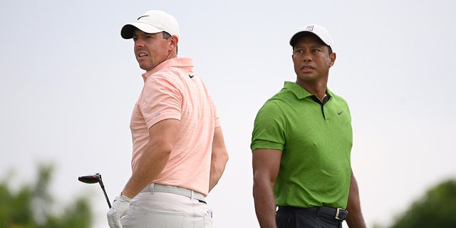 Rory McIlroy of Northern Ireland and Tiger Woods of the United States watch a tee shot on the 10th tee during the second round of the 2022 PGA Championship at Southern Hills Country Club May 20, 2022, in Tulsa, Okla.