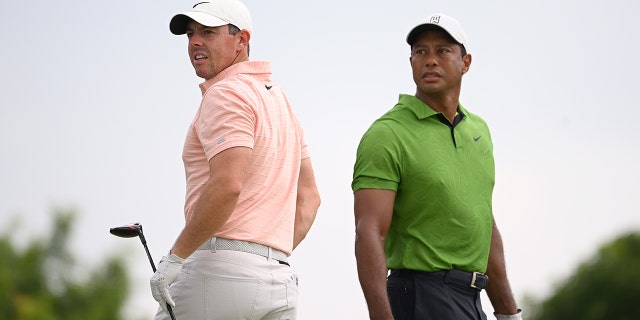 Rory McIlroy of Northern Ireland and Tiger Woods of the United States watch a tee shot on the 10th tee during the second round of the 2022 PGA Championship at Southern Hills Country Club May 20, 2022, in Tulsa, Okla.