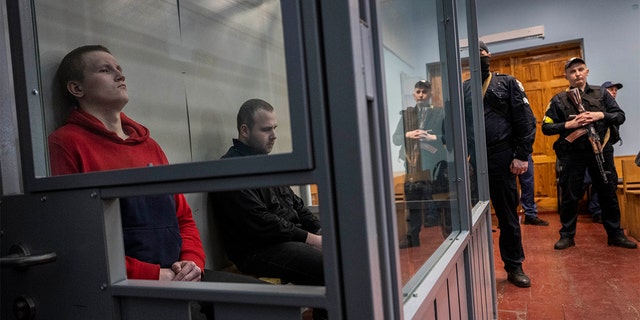 Russian soldiers Alexander Alexeevich Ivanov and Alexander Vladimirovich Bobykin, left, attend their trial hearing in Kotelva, northeastern Ukraine, Thursday, May 26, 2022. (AP Photo/Bernat Armangue)