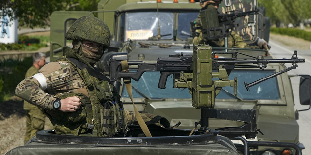 Russian soldiers are seen standing atop their military vehicles near the Zaporizhzhia Nuclear Power Station in southeastern Ukraine on Sunday, May 1.