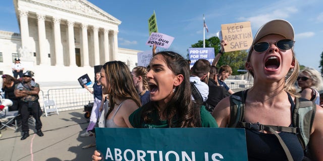 Demonstrators protest outside the U.S. Supreme Court, Tuesday, May 3, 2022 in Washington. The traditionally insular Supreme Court is about to face the full force of public pressure and abortion politics. Justices are deciding whether to throw out the landmark Roe v. Wade ruling. A leaked draft opinion suggests the conservative justices are prepared to overturn the 1973 opinion that gives women legal access to the procedure. 