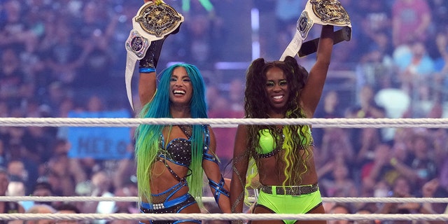 Apr 3, 2022; Arlington, TX, USA; Sasha Banks (left) and Naomi celebrate after the women’s Tag Team Championship fatal four way match during WrestleMania at AT&amp;T Stadium.