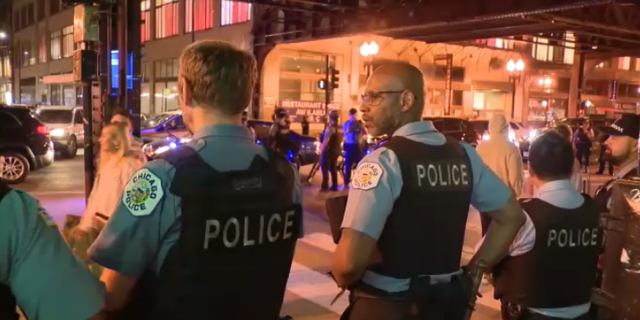 La policía recorre las calles del centro de Chicago después de que un niño de 16 años fuera asesinado a tiros en Millennium Park el sábado 14 de mayo de 2022 por la noche.