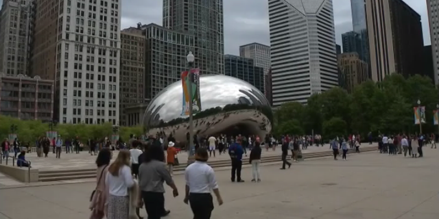 Tourists gather near Chicago's famous "Cloud Gate" beeldhouwerk, also known as "The Bean," following a deadly shooting.