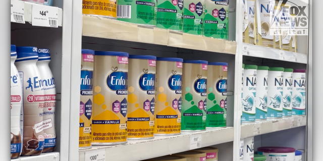 Baby formula cans are shown on shelves at a pharmacy in Tijuana, Mexico. 