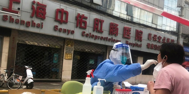 Pracownik służby zdrowia przeprowadza testy na obecność COVID-19 na mieszkańcach 10 kwietnia 2022 r. w Szanghaju w Chinach.