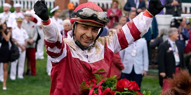 Jockey Sonny Leon celebrates in the winner's circle after Rich Strike won the 148th running of the Kentucky Derby horse race at Churchill Downs, Saturday, May 7, 2022, in Louisville, Ky. 