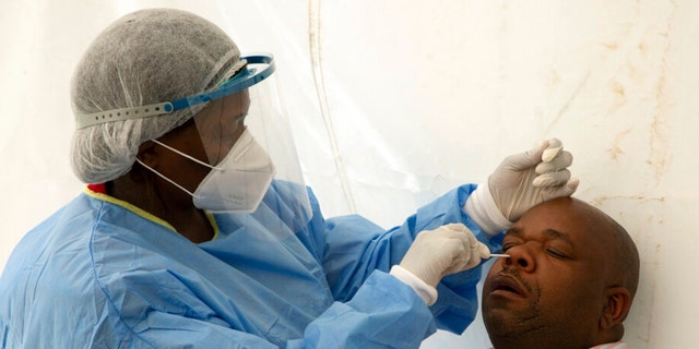 A patient undergoes a nasal swab to check for COVID-19 at a testing centre in Soweto, South Africa, Wednesday, May 11, 2022. 