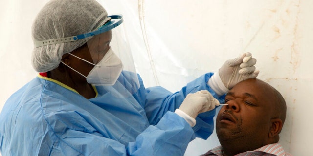 A patient undergoes a nasal swab to check for COVID-19 at a testing centre in Soweto, South Africa, Wednesday, May 11, 2022. 