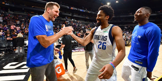 Dirk Nowitzki high fives Spencer Dinwiddie #26 of the Dallas Mavericks after Game 7 of the 2022 NBA Playoffs Western Conference Semifinals on May 15, 2022 at Footprint Center in Phoenix, Arizona.