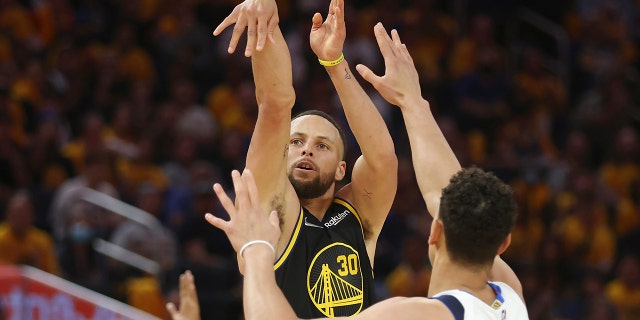 金州勇士队后卫斯蒂芬库里 (30) watches his 3-point basket against Dallas Mavericks center Dwight Powell during the second half of Game 1 of the NBA basketball playoffs Western Conference finals in San Francisco, 星期三, 可能 18, 2022.