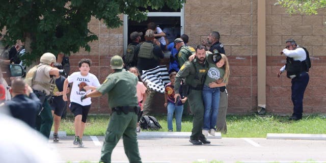 Children run to safety after escaping from a window during a mass shooting at Robb Elementary School where a gunman killed nineteen children and two adults in Uvalde, Texas, May 24, 2022. 