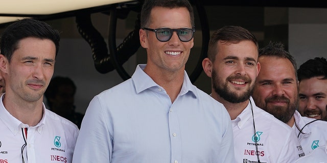 Tom Brady with the Mercedes mechanics.