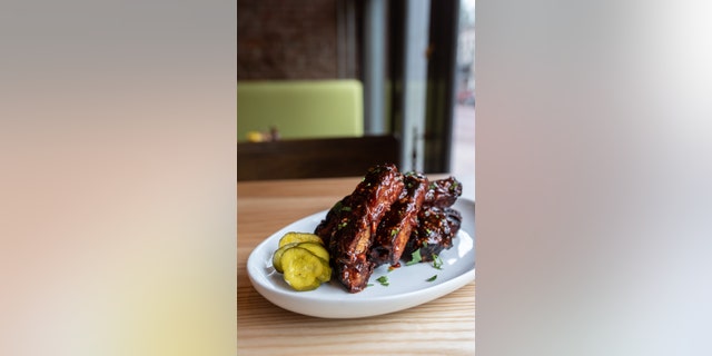 Chef and Pitmaster Haley Riley of Salt + Smoke restaurant in St. ルイ, ミズーリ, smothers his ribs in barbecue sauce mixed with garlic and parsley.
