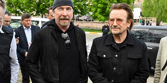 Bono (R) (Paul David Hewson), activist and frontman of the Irish rock band U2 and guitarist David Howell Evans aka 'The Edge' (L) visits the site of a mass grave by the Church of St. Andrew Pervozvannoho All Saints in the Ukrainian town of Bucha, near Kyiv on May 8, 2022.