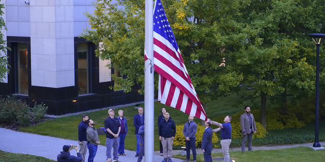 Employees of the U.S. embassy in Ukraine raise the American flag on Wednesday, May 18. (AP)