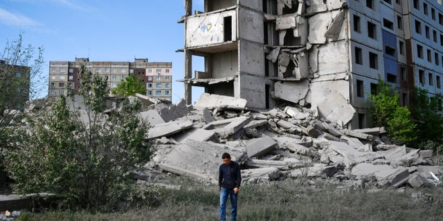 A resident walks next to a house destroyed by Russian shelling in Kramatorsk, Ukraine.