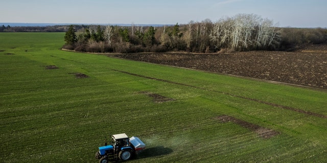 يُظهر منظر جوي جرارًا ينشر الأسمدة في حقل قمح.  تخطط الحكومة الهولندية لإغلاق ما يصل إلى 3000 مزرعة في محاولة للامتثال للتفويض البيئي للاتحاد الأوروبي. 