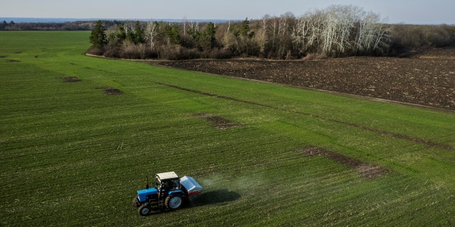 An aerial view shows a tractor spreading fertilizer on a wheat field. The Dutch government plans to close down up to 3,000 farms in an effort to comply with a European Union environmental mandate. 