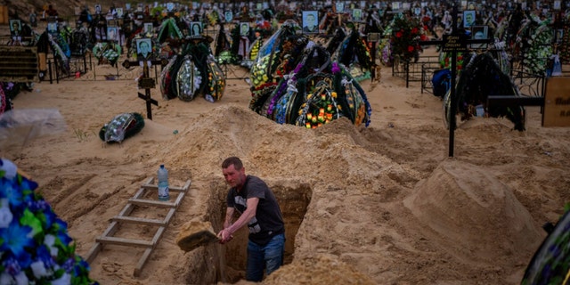 Gravedigger Alexander, digs a grave at the cemetery of Irpin, on the outskirts of Kyiv, on Wednesday, April 27, 2022. 