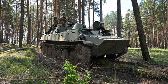 Ukrainske soldater blir sett ri på en pansret personellvogn under en øvelse ikke langt fra Kharkiv 30. april.