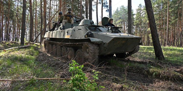 Ukrainian soldiers are seen riding on an armored personnel carrier during an exercise not far from Kharkiv on April 30.