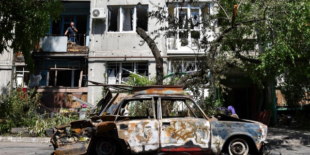 A destroyed car lies next to an apartment building damaged by an overnight missile strike in Sloviansk, Ukraine, Tuesday, May 31, 2022.