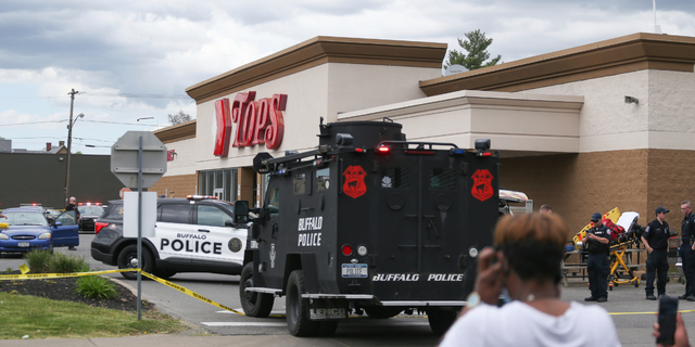 A crowd gathers as police investigate after a shooting at a supermarket on Saturday, May 14, 2022, in Buffalo, N.Y. 
