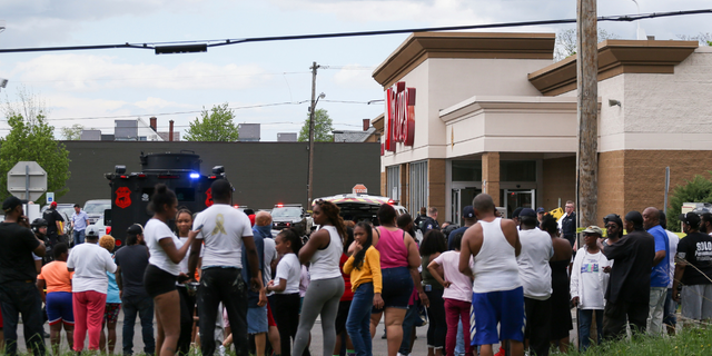 A crowd gathers as police investigate after a shooting at a supermarket on Saturday, May 14, 2022, in Buffalo, N.Y. 
