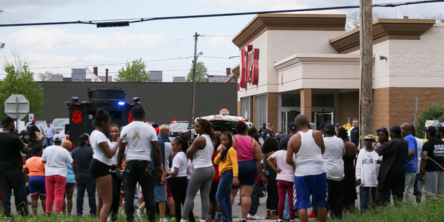 A crowd gathers as police investigate after a shooting at a supermarket on Saturday, May 14, 2022, in Buffalo, N.Y. Multiple people were shot at the Tops Friendly Market. Police have notified the public that the alleged shooter was in custody.