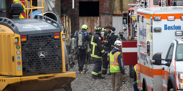 Boston firefighters and construction workers gather at a construction site outside a former power plant, where workers were injured, Wednesday May 4, 2022, in the South Boston neighborhood of Boston. At least three people were injured, and there were reports of multiple people trapped during a partial collapse at a Boston construction site on Wednesday afternoon, authorities said.