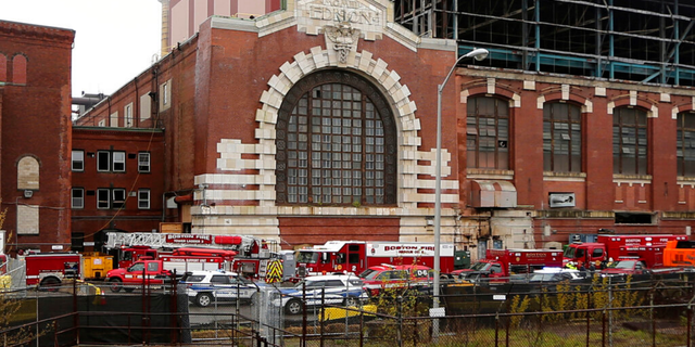 Boston firefighters and construction workers gather at a construction site outside a former power plant, where workers were injured, Wednesday May 4, 2022, in the South Boston neighborhood of Boston. At least three people were injured, and there were reports of multiple people trapped during a partial collapse at a Boston construction site on Wednesday afternoon, authorities said.