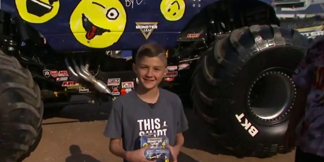 کالوین بیمار سنت جود، کامیون اسباب بازی Monster Jam خود را در حالی که با کامیون هیولایی Monster Jam که با طرح اصلی او تزئین شده است، ژست گرفته است. "روباه و دوستان،" در 19 مه 2022. (فاکس نیوز)