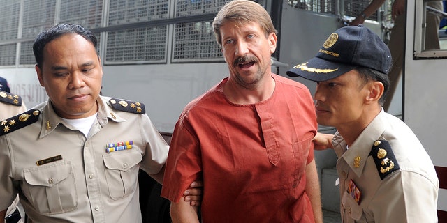 Viktor Bout, an alleged Russian arms dealer, is escorted by police as he arrives for a hearing at a criminal court in Bangkok.