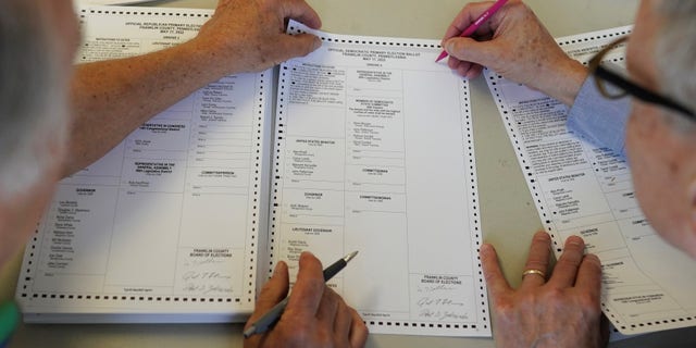 Bob Ziobrowski, right, and Jerry Warnement review duplicate and damaged absentee and mail-in ballots at the Franklin County offices in Chambersburg, Pennsylvania, Wednesday, May 18, 2022.