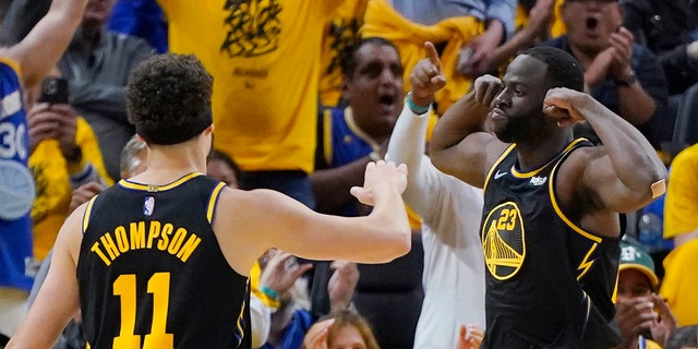 Golden State Warriors forward Draymond Green (23) celebrates next to guard Klay Thompson (11) during the first half in Game 5 of the team's NBA Conference finals matchup against the Dallas Mavericks in San Francisco Thursday, May 26, 2022.