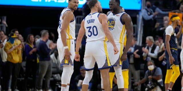 Golden State Warriors' Otto Porter Jr., izquierda, Stephen Curry (30) and Draymond Green (23) celebrate in the final seconds against the Memphis Grizzlies during the second half of Game 4 of an NBA basketball Western Conference playoff semifinal in San Francisco, lunes, Mayo 9, 2022. Warriors won 101-98.
