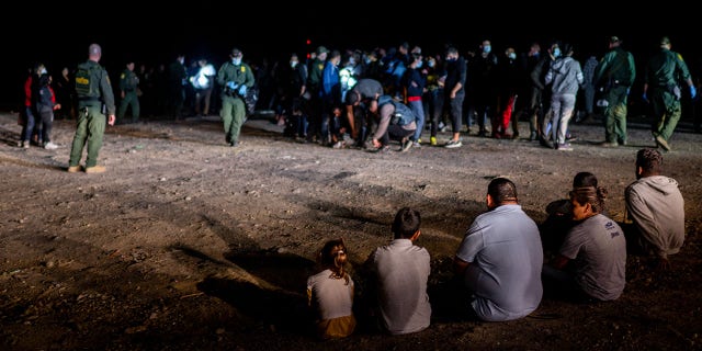 A migrant family sits after being processed May 5, 2022, in Roma, Texas. 