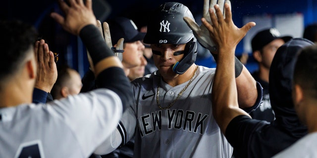 Aaron Judge #99 of the New York Yankees celebrates a solo home run in the dugout during the sixth inning of their MLB game against the Toronto Blue Jays at Rogers Centre on May 3, 2022 in Toronto, Canada.