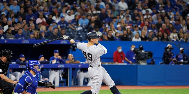 Aaron Judge #99 of the New York Yankees hits an RBI double, batting in Aaron Hicks #31, in the seventh inning of their MLB game against the Toronto Blue Jays at Rogers Centre on May 3, 2022 in Toronto, Canada. 