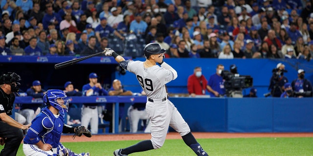 Aaron Judge #99 of the New York Yankees hits an RBI double, batting in Aaron Hicks #31, in the seventh inning of their MLB game against the Toronto Blue Jays at Rogers Centre on May 3, 2022 in Toronto, Canada.