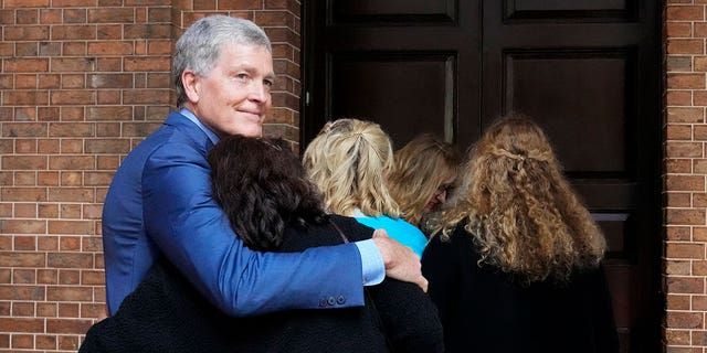 Steve Johnson, brother of U.S. murder victim Scott Johnson, hugs his wife Rosemarie as they arrive at the Supreme Court in Sydney, Monday, May 2, 2022.