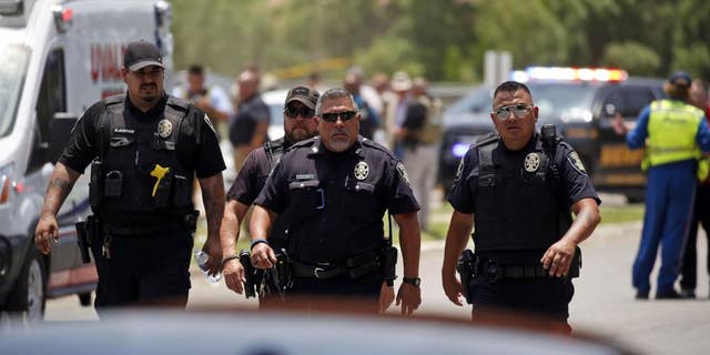 Police walk near Robb Elementary School following a shooting, martedì, Maggio 24, 2022, a Uvalde, Texas
