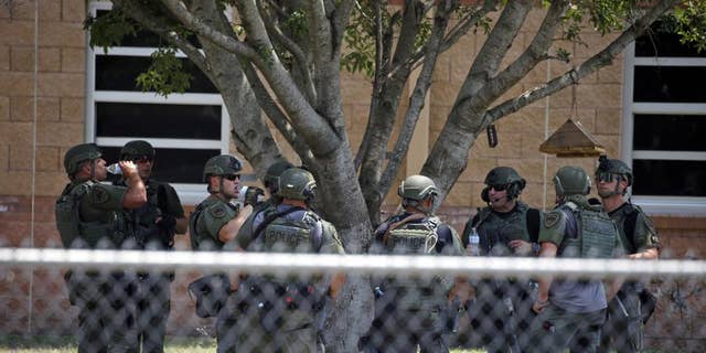 El personal encargado de hacer cumplir la ley se encuentra frente a la Escuela Primaria Robb luego de un tiroteo en Uvalde, Texas, el 24 de mayo.