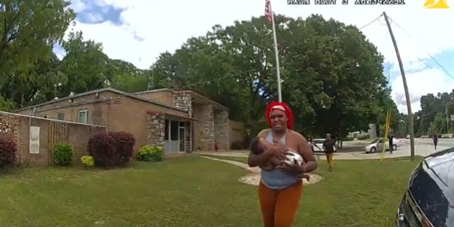 In SPO Oden's body-worn camera footage, a woman can be seen approaching the officer and handing him the 4-month-old baby, who "was not breathing" at the time, according to police.
