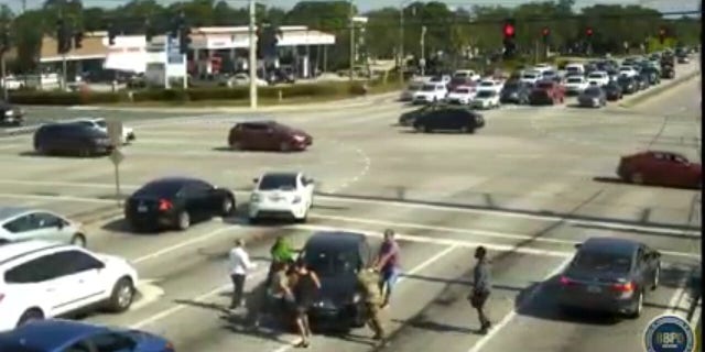 Boyton Beach are seeking the identities are Good Samaritans seen on stunning traffic camera video springing into action to help a woman who suffered a medical emergency while behind the wheel.