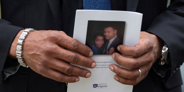 A person holds a program for the funeral service for Aaron Salter Jr., Wednesday, May 25, 2022, in Getzville, New York. Salter was killed in the Buffalo supermarket shooting on May 14.