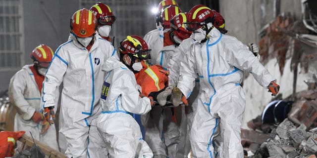 In this photo released by Xinhua News Agency, rescue workers evacuate the 10th survivor who was pulled alive after being trapped 132 hours in the debris of a collapsed self-built residential structure in Changsha, Hunan province (Central China), Thursday, May 5, 2022. Rescuers in Central China pulled the living woman from the rubble of a building that had partially collapsed nearly six days earlier, media reported Thursday. officials. (Shen Hong/Xinhua via AP)